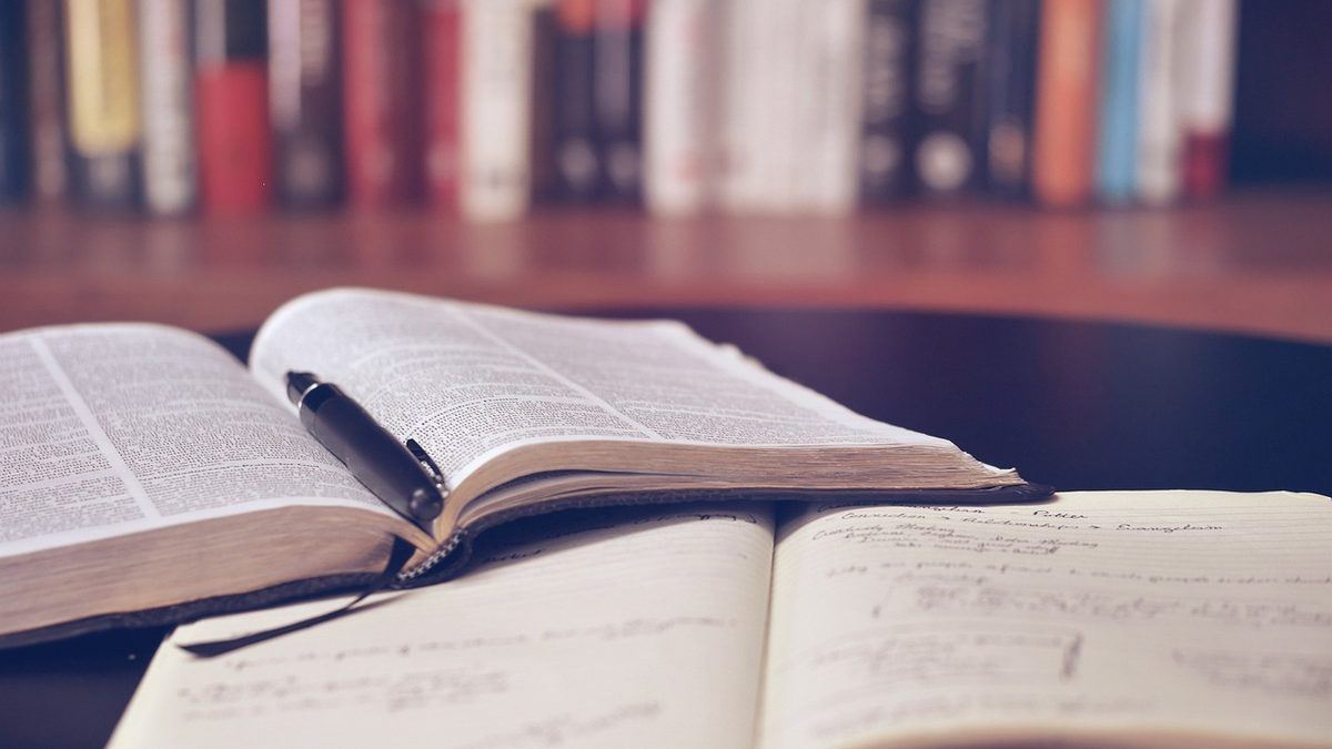 Manuals and books, open on the desk